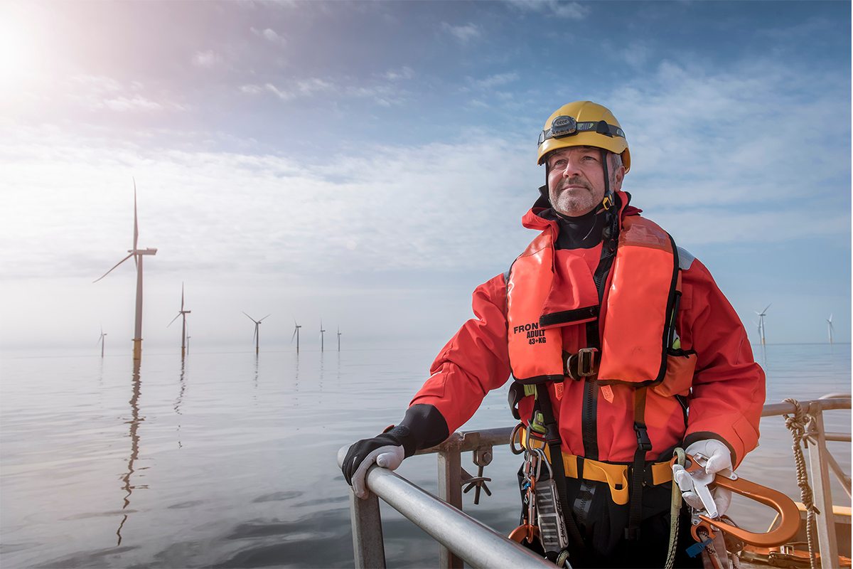 Man on platform near offshore wind farm